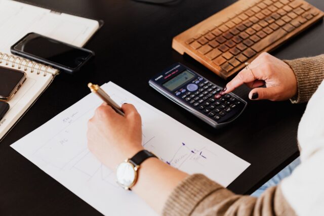 Un pix așezat pe un contract tipărit, lângă un calculator de birou