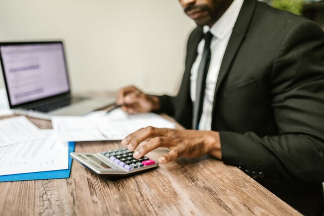 Documente de asigurare, un calculator și un pix așezate pe un birou, pregătite pentru comparație